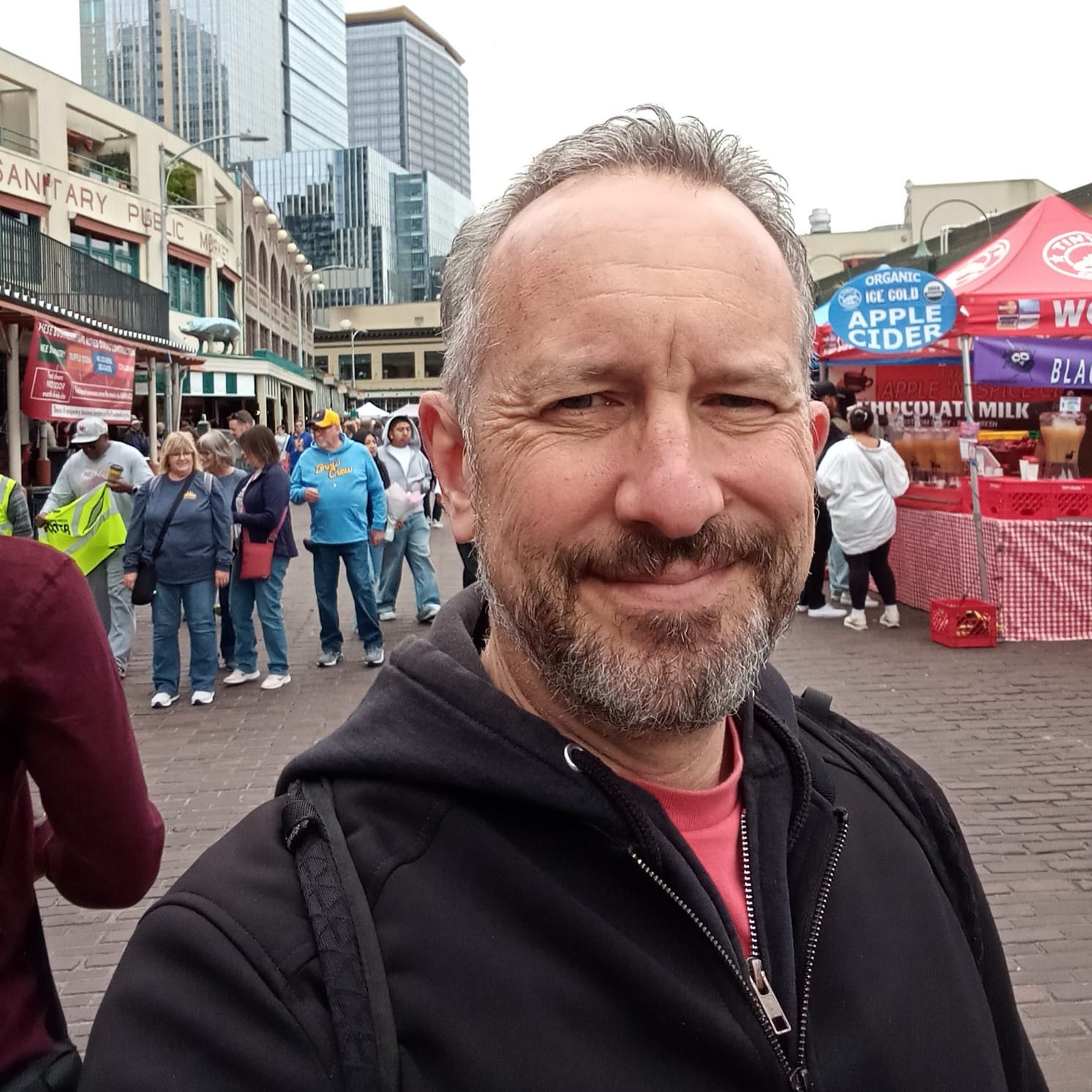 Andrew Engelson stands in on the cobbled street in Pike Place market with tourists, shoppers and no cars.
