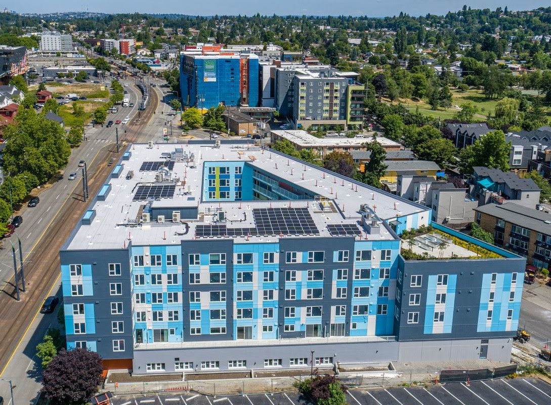 And aerial photo of a six-story apartment building with interior courtyard and brightly colored in shades of blue