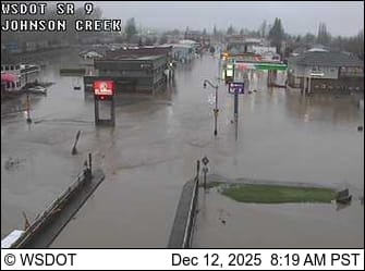 A remote camera view of a town and commercial buildings under flood waters