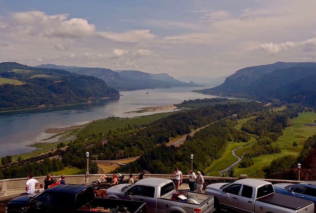 Motorists parked at a viewpoint look out at the Columbia River Gorge.