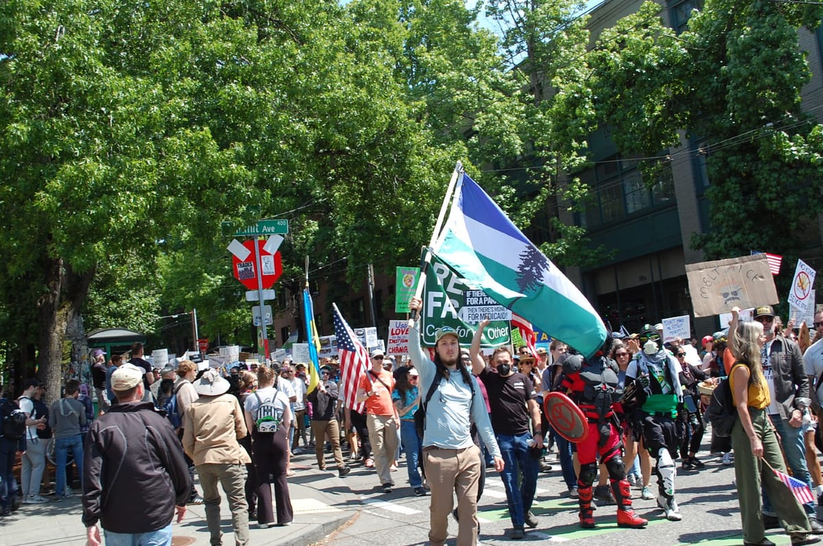 At a crowded march on a street in Seattle's Capitol Hill Neighborhood a protester waves a Cascadia Doug flag