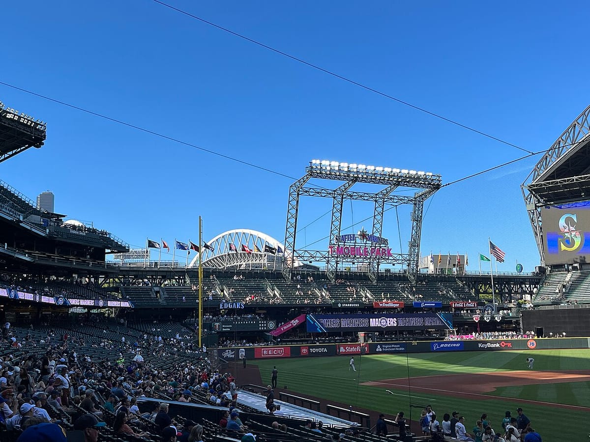 A small crowd at T Mobile baseball park with a blue sky and the Columbia tower in the distance.