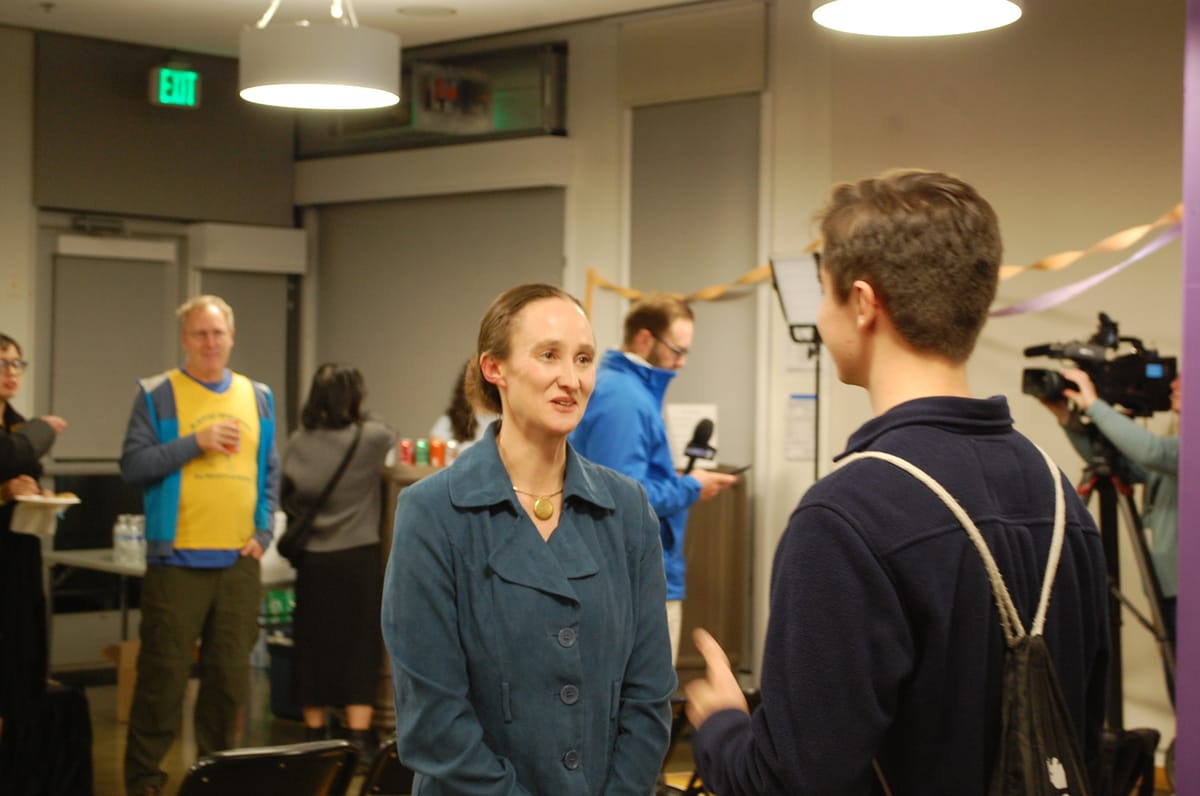 Katie Wilson speaks with a campaign volunteer on election night.