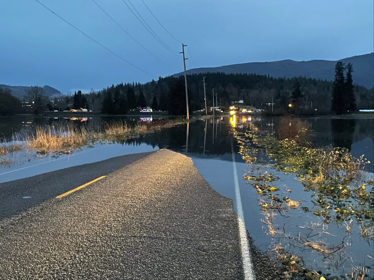 A road covered in water as night descends