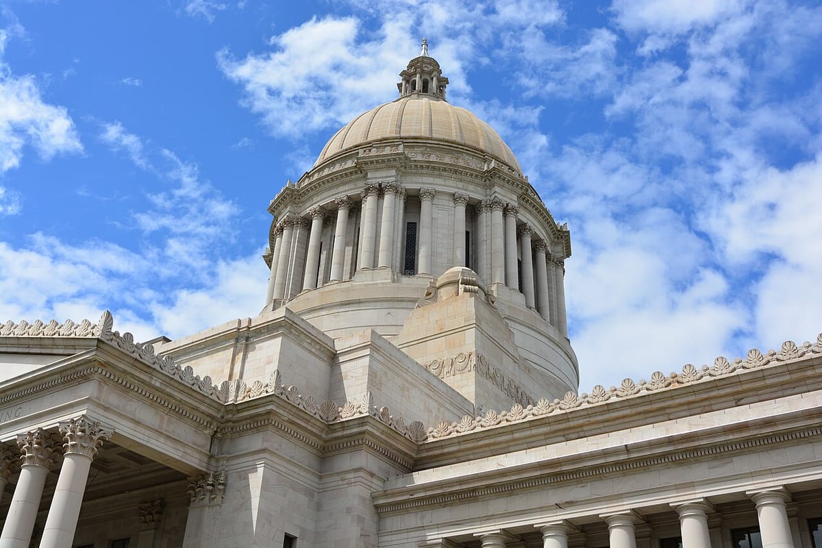 The dome of the Washington state legislative building under a blue sky filled with clouds