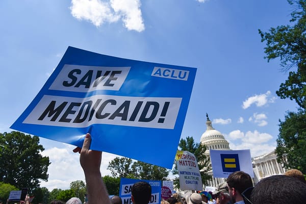 A sign reading SAVE MEDICAID is held aloft at a protest outside the US Capitol