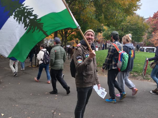 Andrew Engelson holds a Cascadia flag during a No Kings protest in Seattle Center.