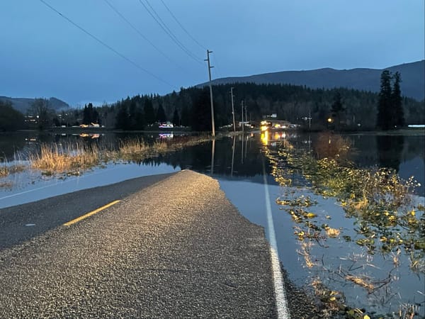 A road covered in water as night descends