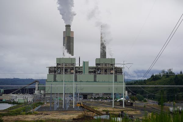 A power plant emits clouds of pollution from two smokestacks.